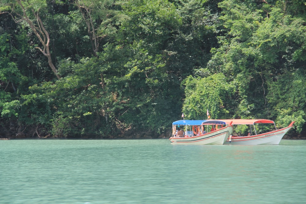 a couple of boats floating on top of a lake