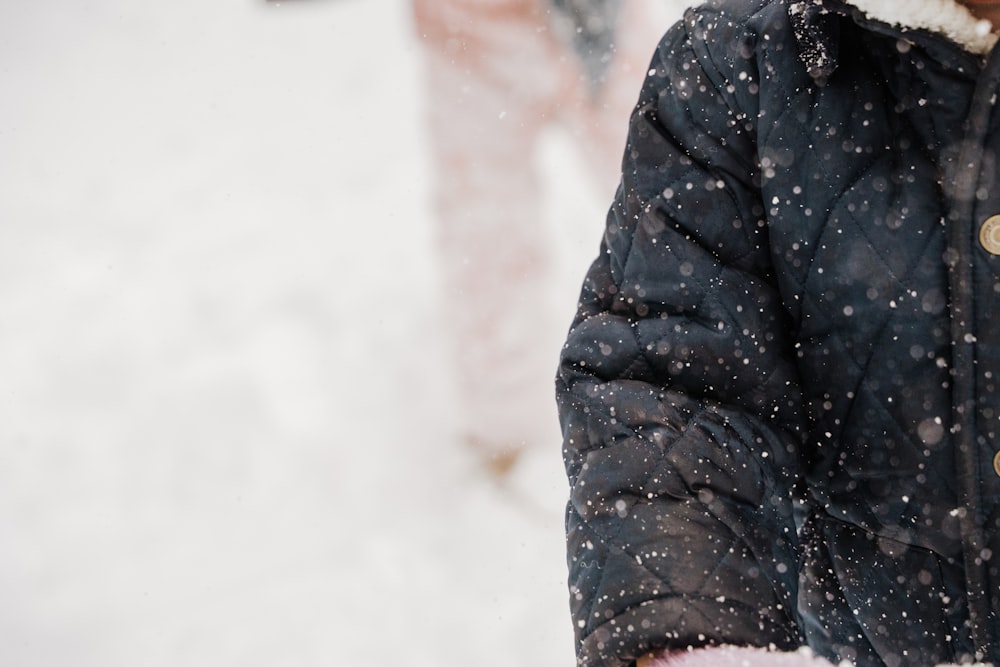 a person walking in the snow with a jacket on