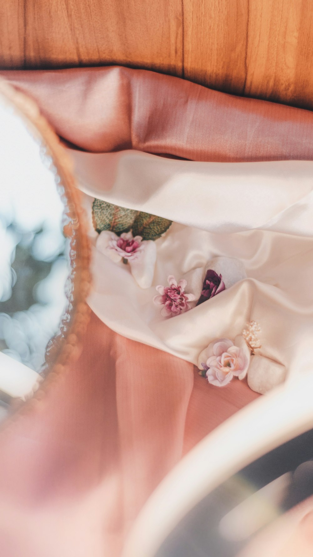 a woman's hand holding a mirror with a flower on it