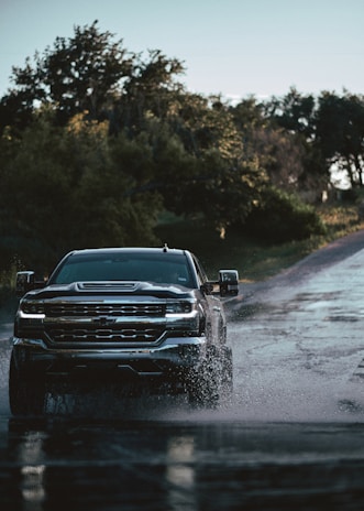 a truck driving down a wet road in the rain