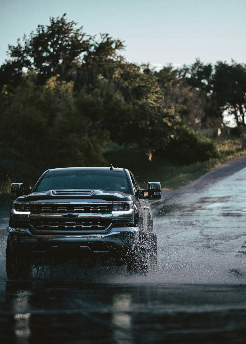 a truck driving down a wet road in the rain