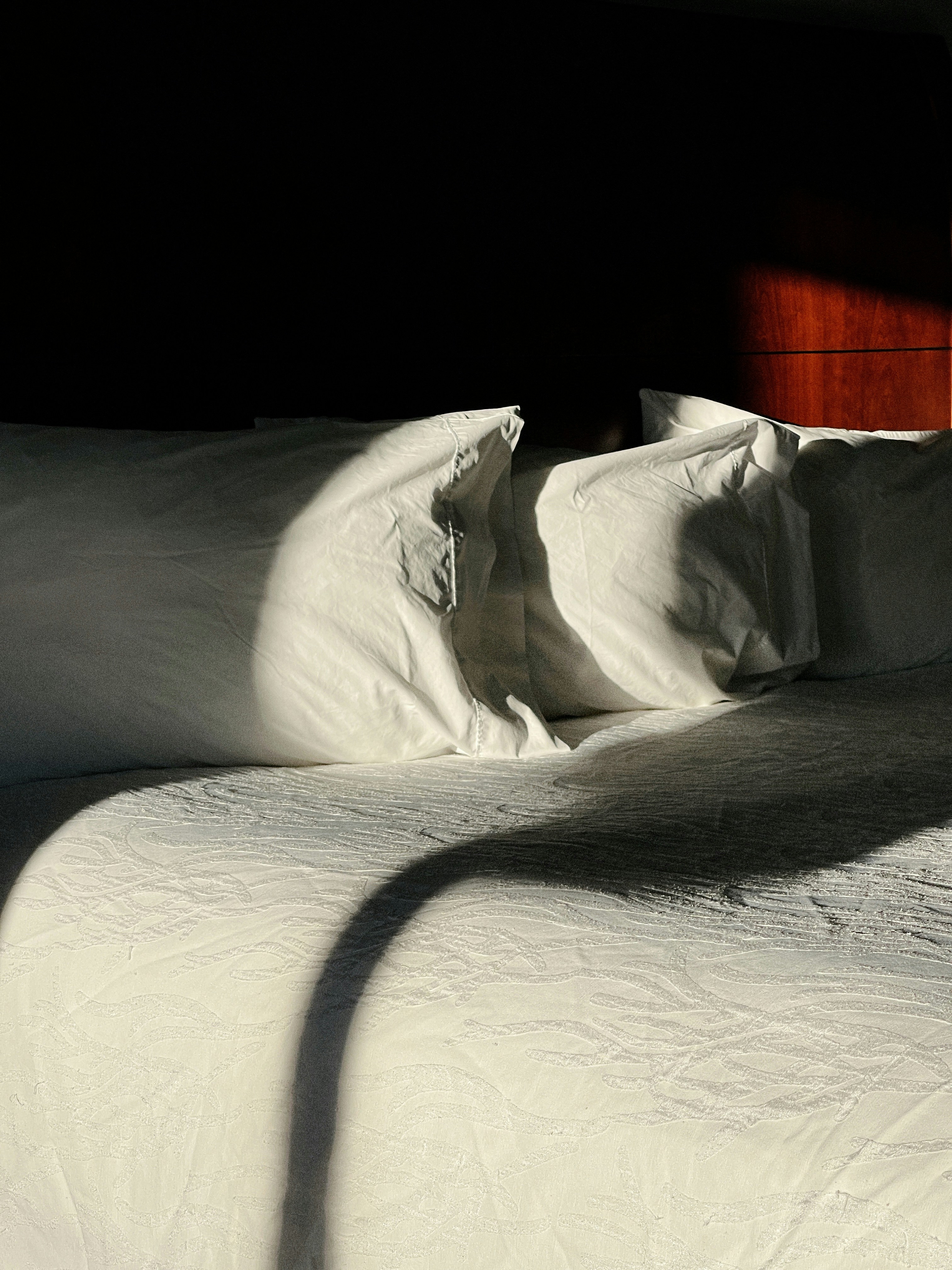a bed with white sheets and white pillows