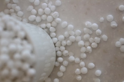 White paraffin wax pellets spilling from a container.