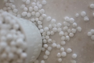 White paraffin wax pellets spilling from a container.