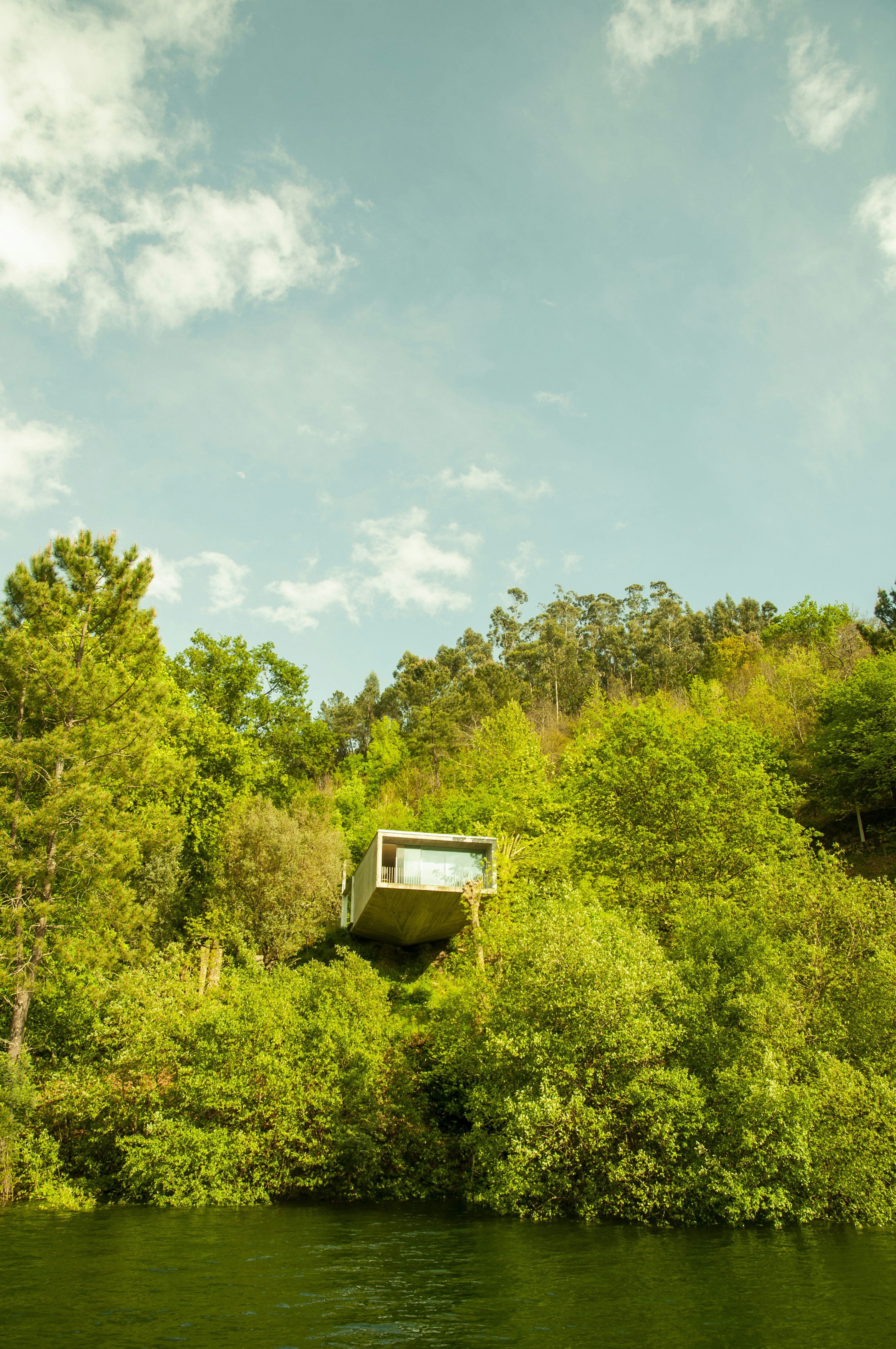 Una casa su una collina sopra uno specchio d'acqua