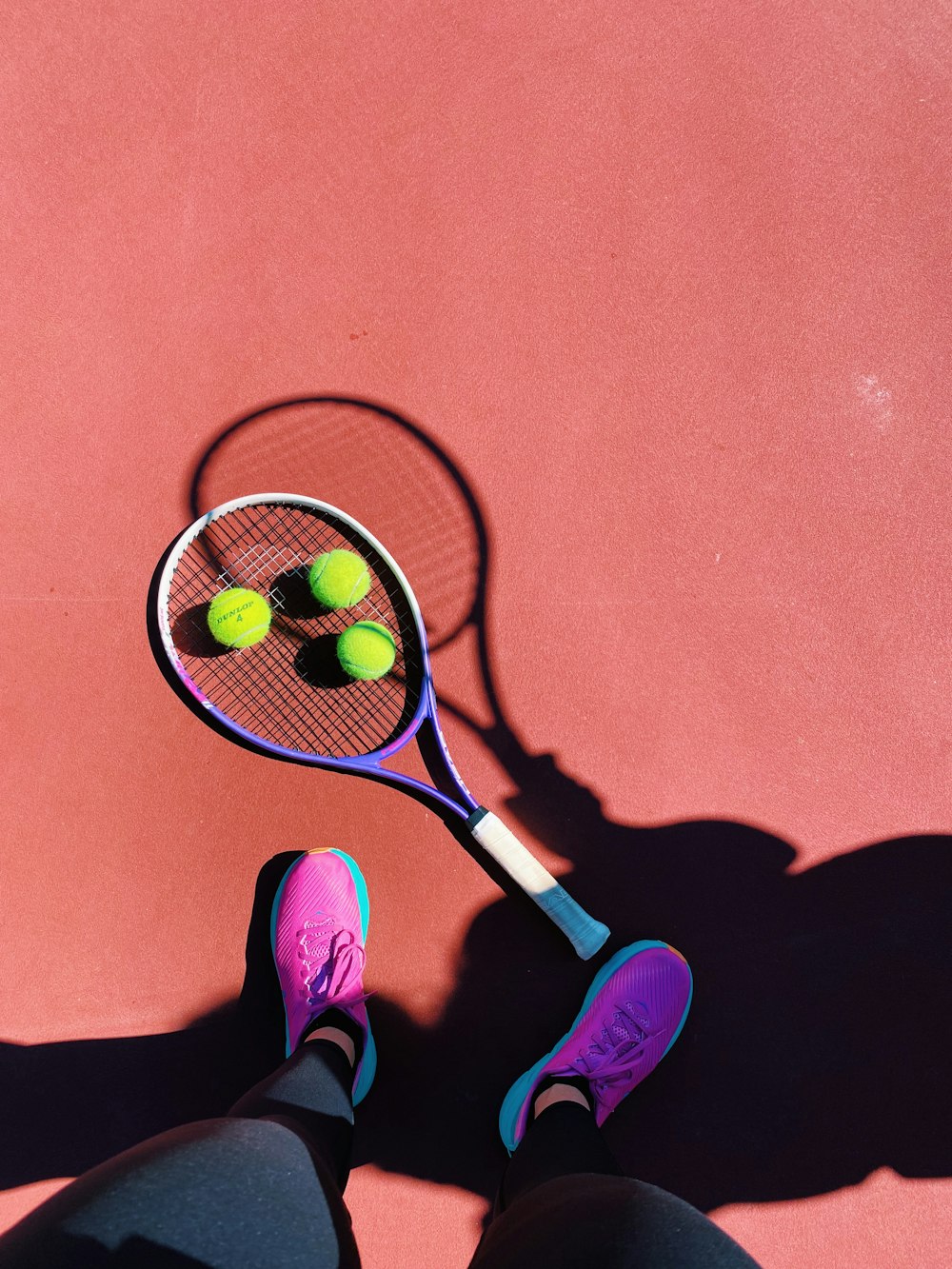 a person standing on a tennis court holding a tennis racket