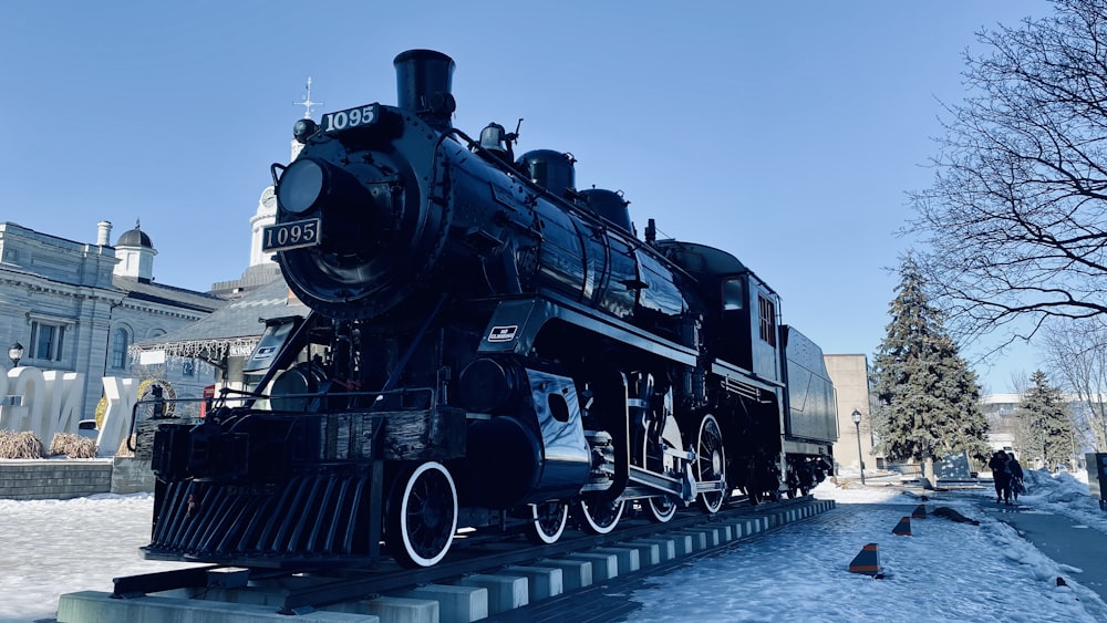 a large black train sitting on top of snow covered ground