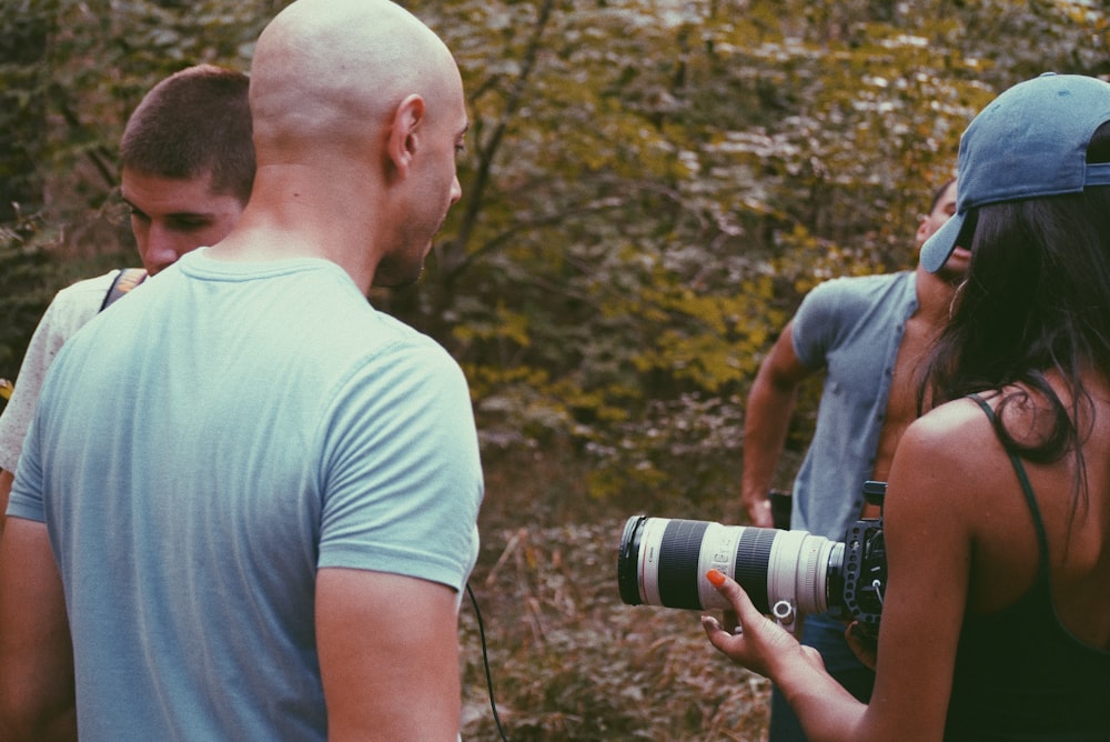 a group of people standing around a man holding a camera