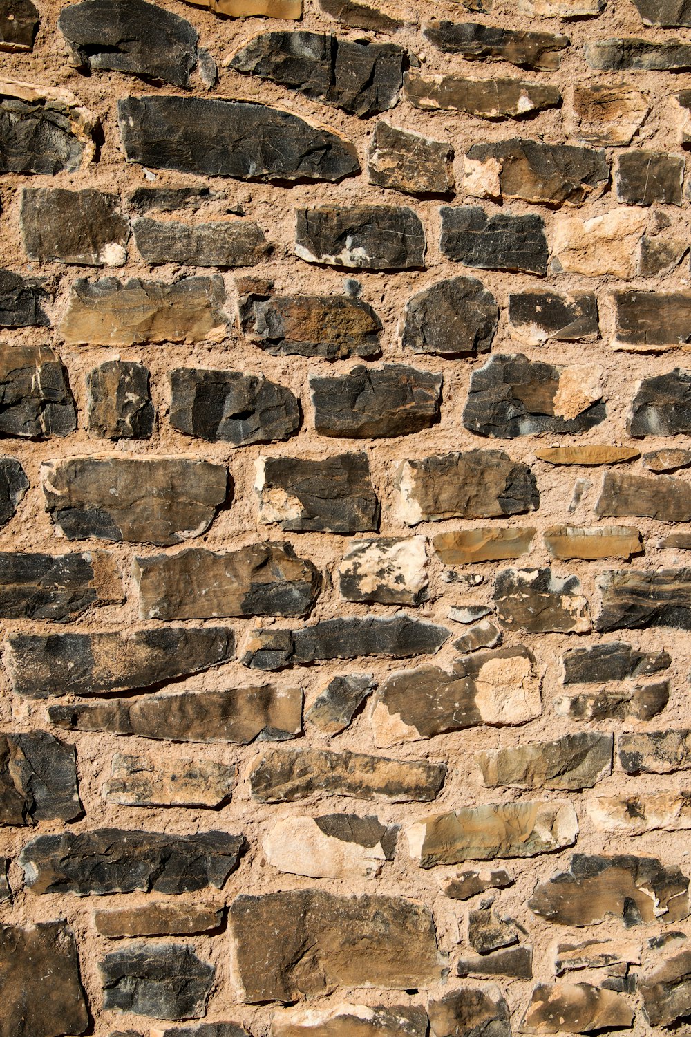 a close up of a stone wall with a clock on it