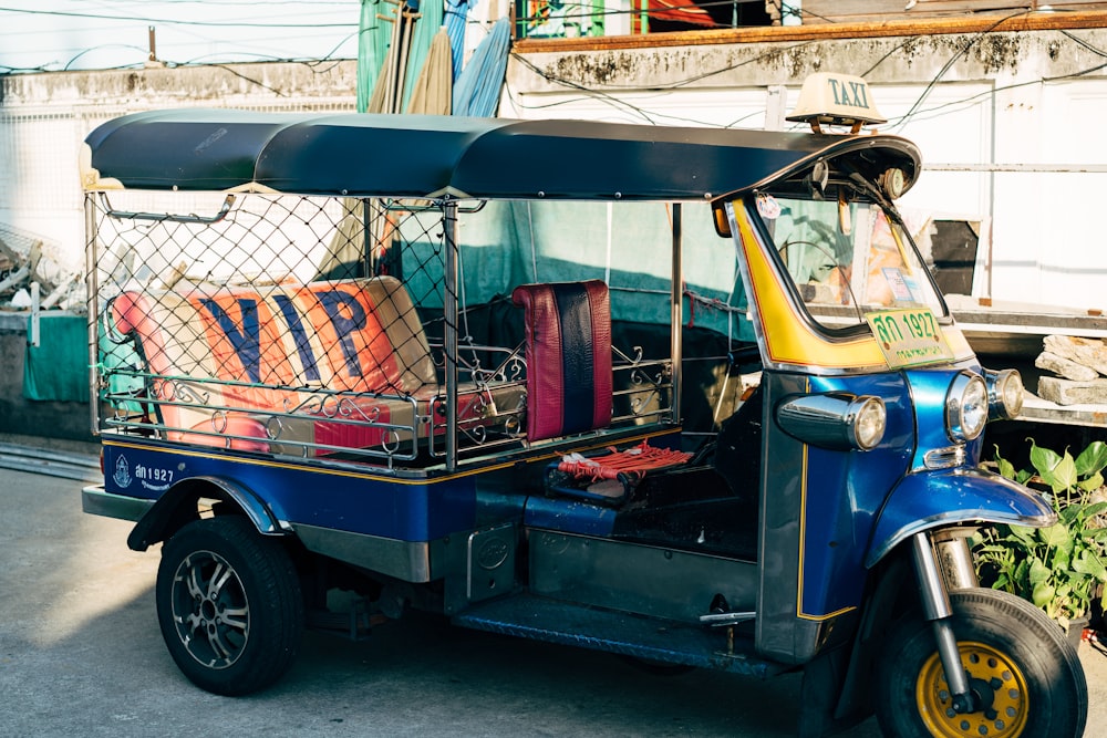 a blue and yellow vehicle with luggage on the back