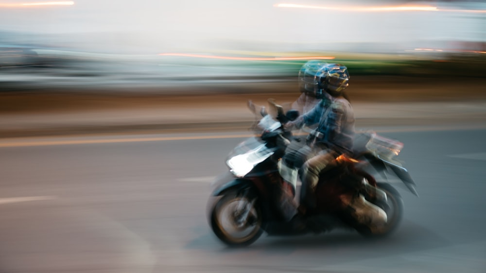 Una foto sfocata di una persona in sella a una motocicletta