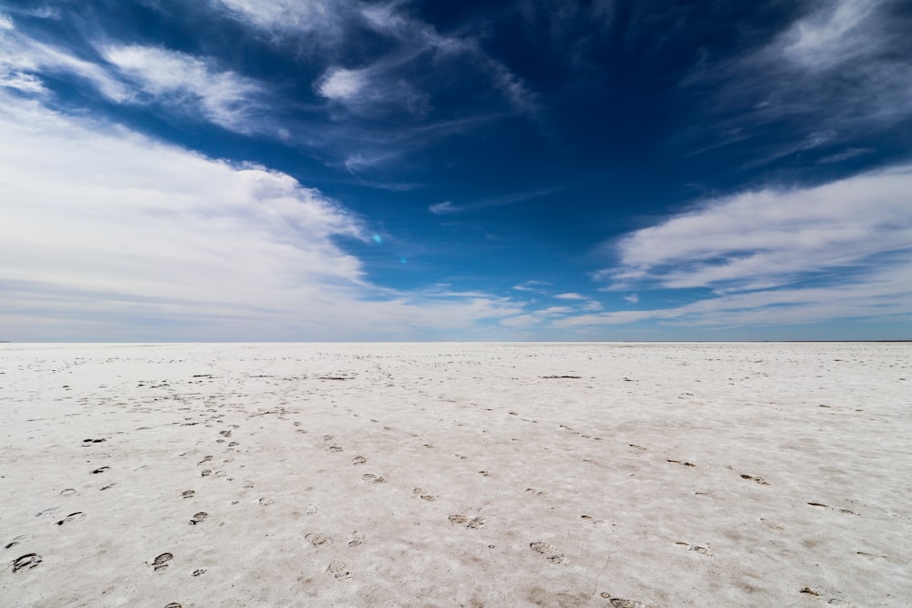 a vast expanse of white sand with footprints in the sand