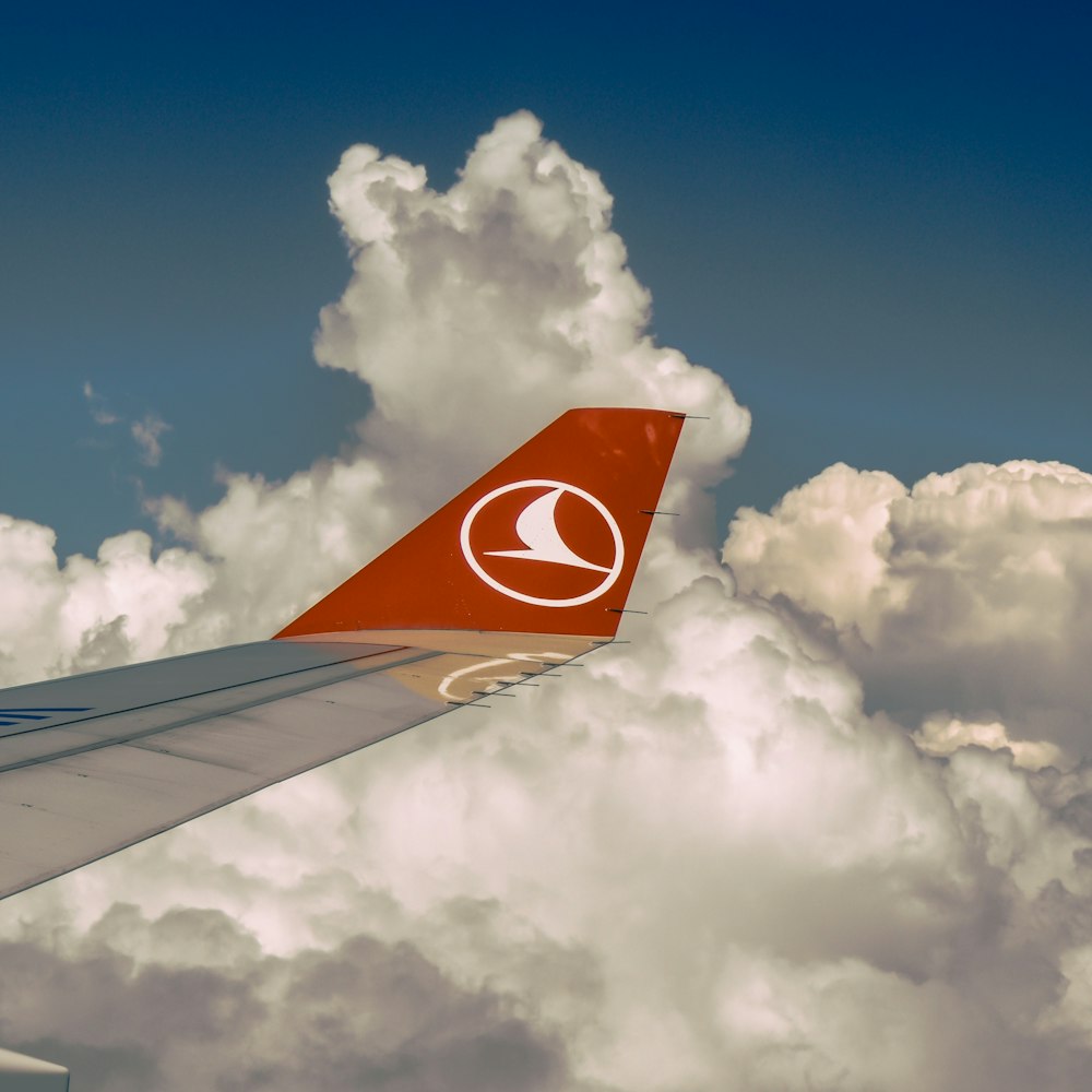 the tail end of an airplane flying through the clouds