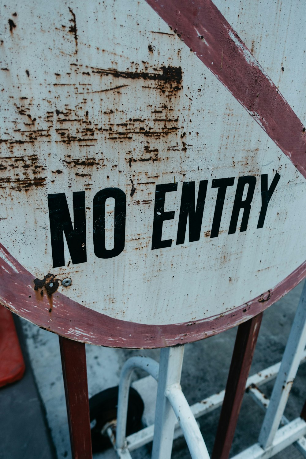 a rusted no entry sign sitting on top of a metal gate