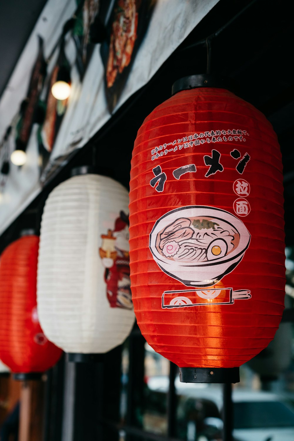 a row of red lanterns hanging from the side of a building