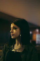 Young person wearing cute neon-accented earrings and bracelets in natural light