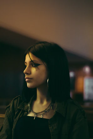 Young person wearing cute neon-accented earrings and bracelets in natural light
