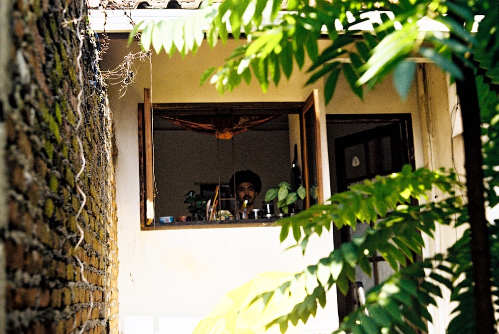 a man is looking out of a window