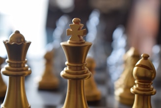 a close up of a chess board with gold pieces