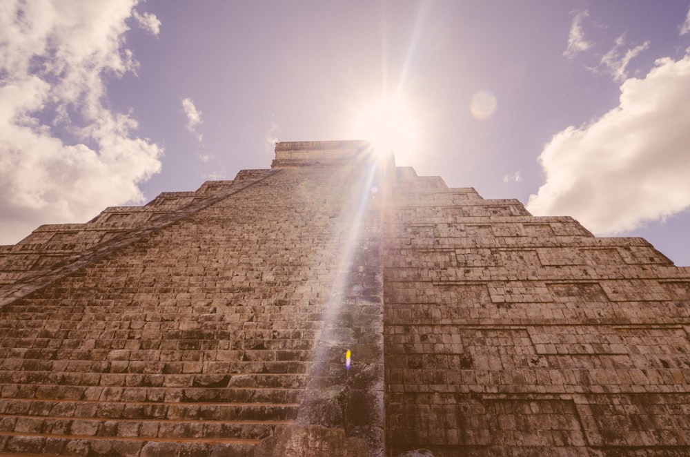 Die Sonne scheint hell durch die Wolken über einer Pyramide