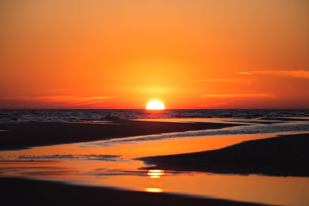 Le soleil se couche sur l’océan sur une plage