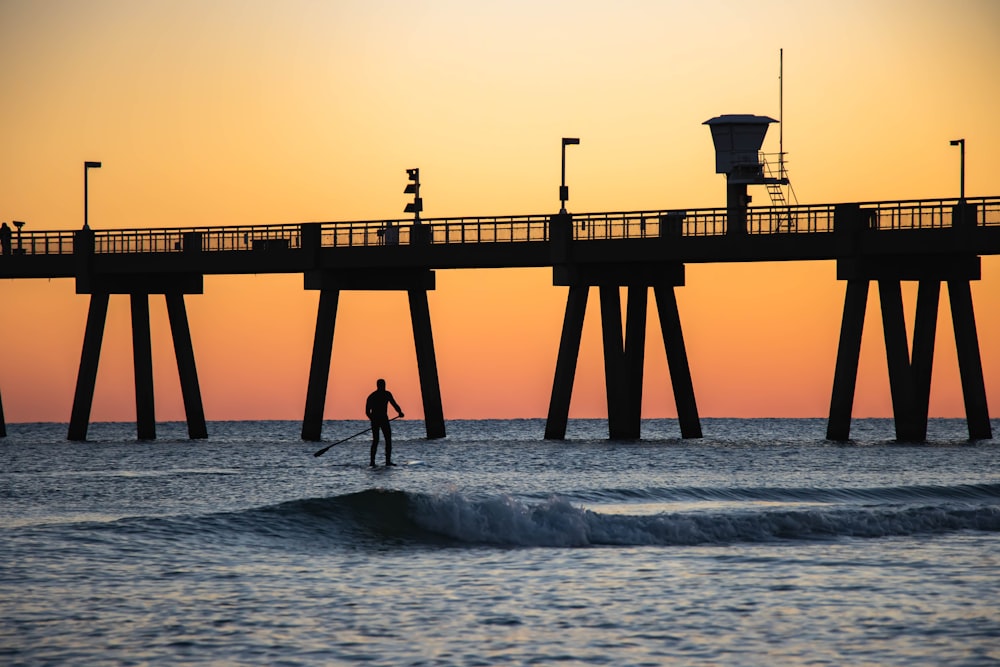 a man riding a surfboard on top of a wave in the ocean