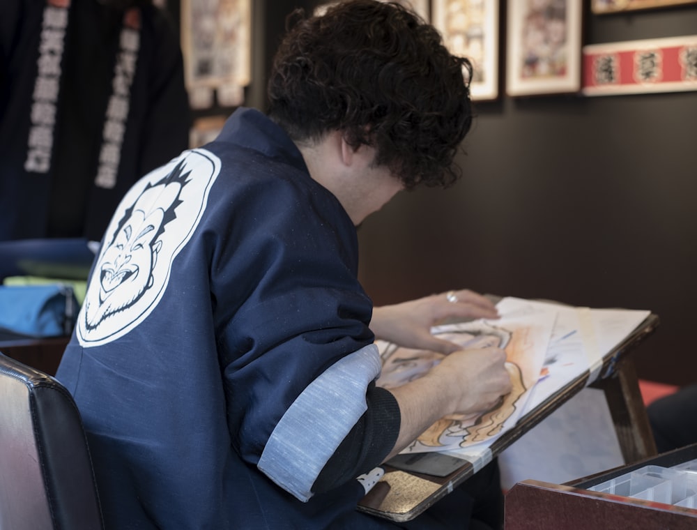 a man sitting at a table with a book in front of him