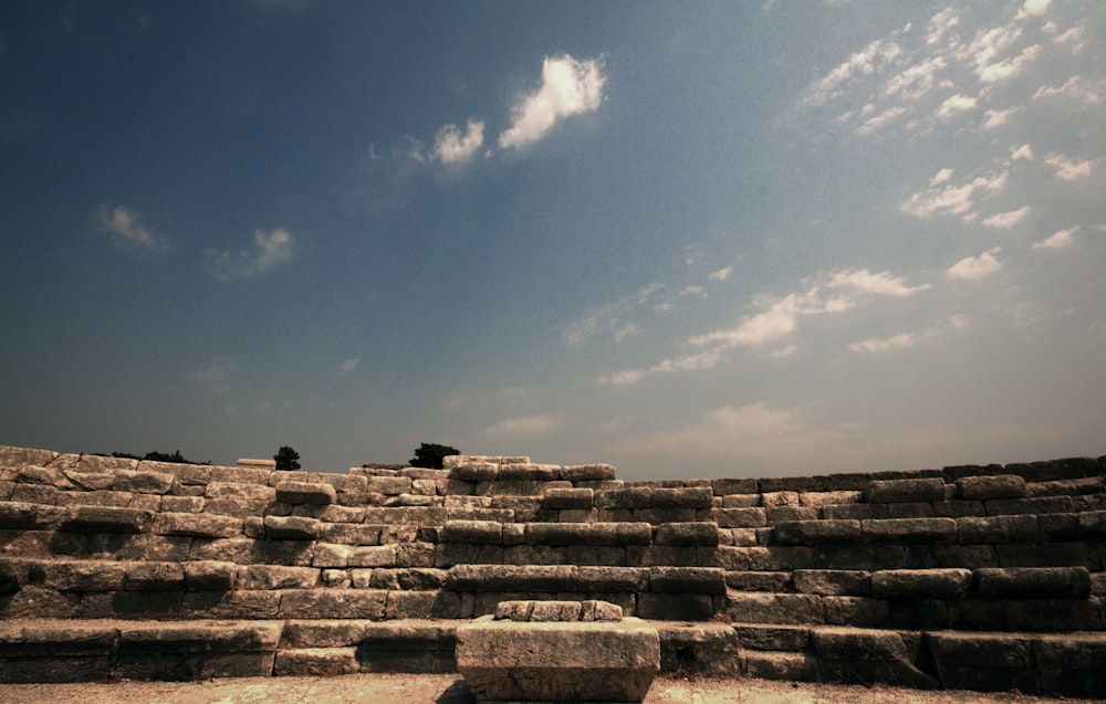 a large stone structure sitting on top of a dirt field