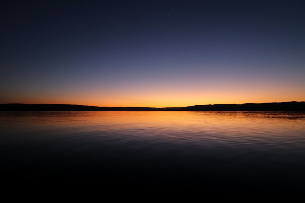 Il sole sta tramontando su un lago calmo