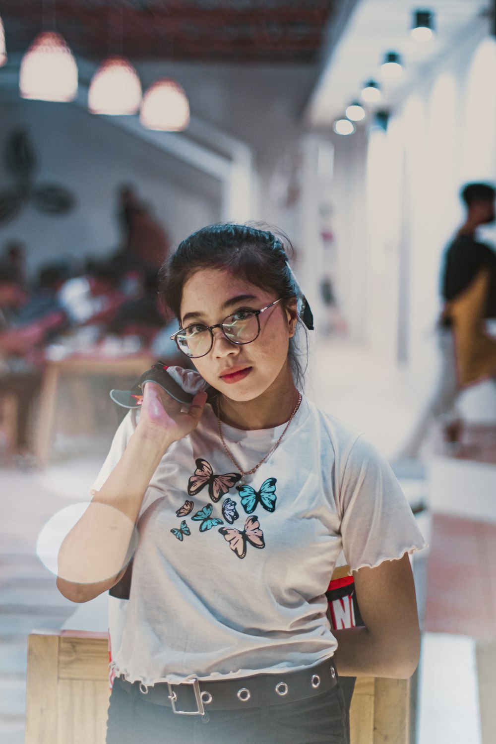 a woman talking on a cell phone while wearing glasses