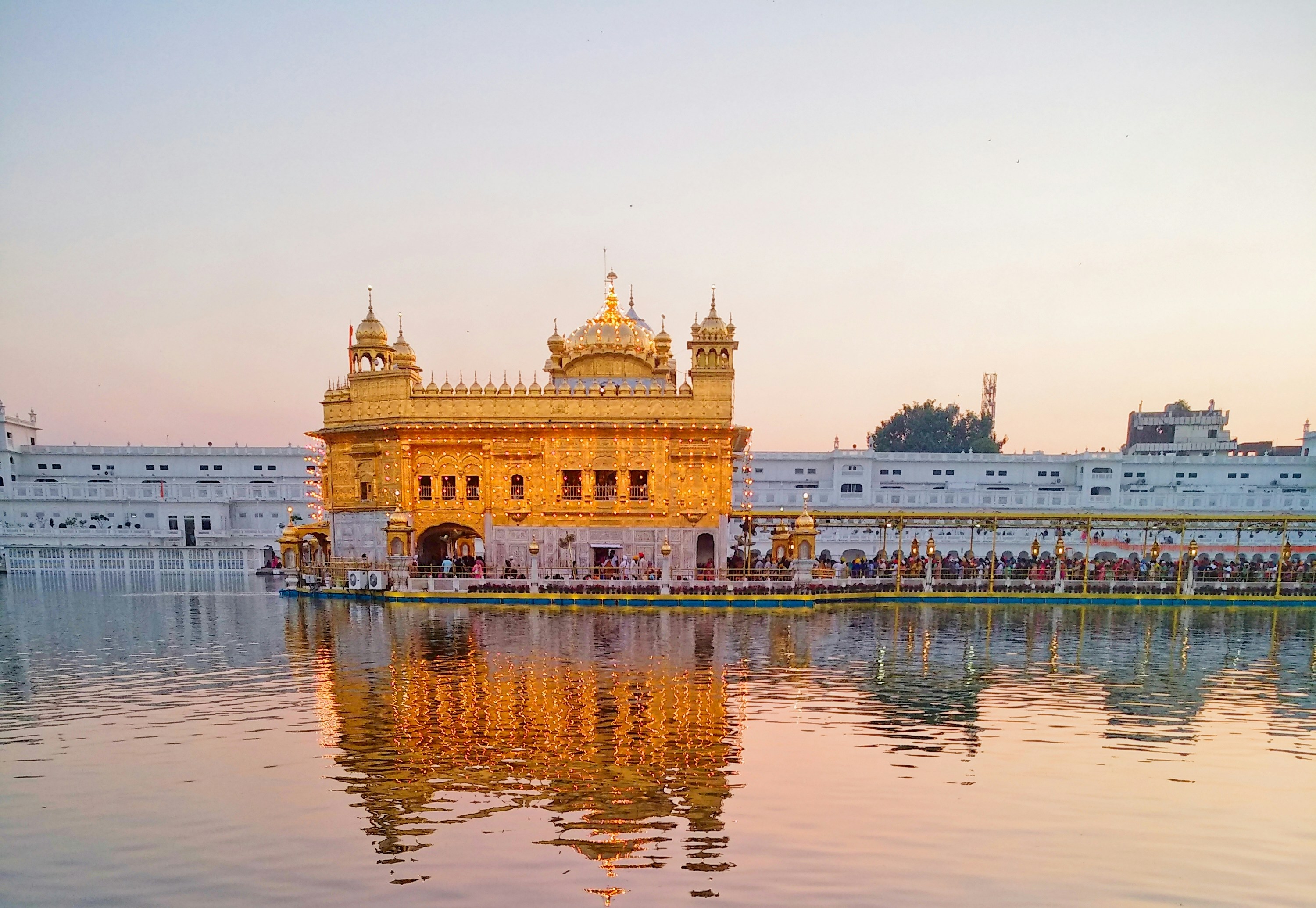 Golden Temple Harmandir Sahib reflecting in the holy sarovar at dawn with soft golden light