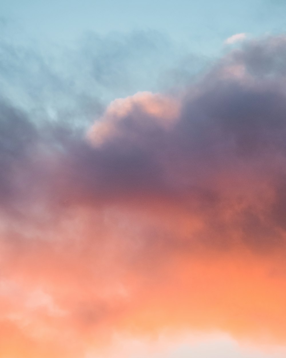 a plane flying in the sky at sunset