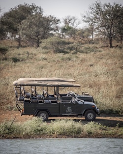 a safari vehicle is parked in a field