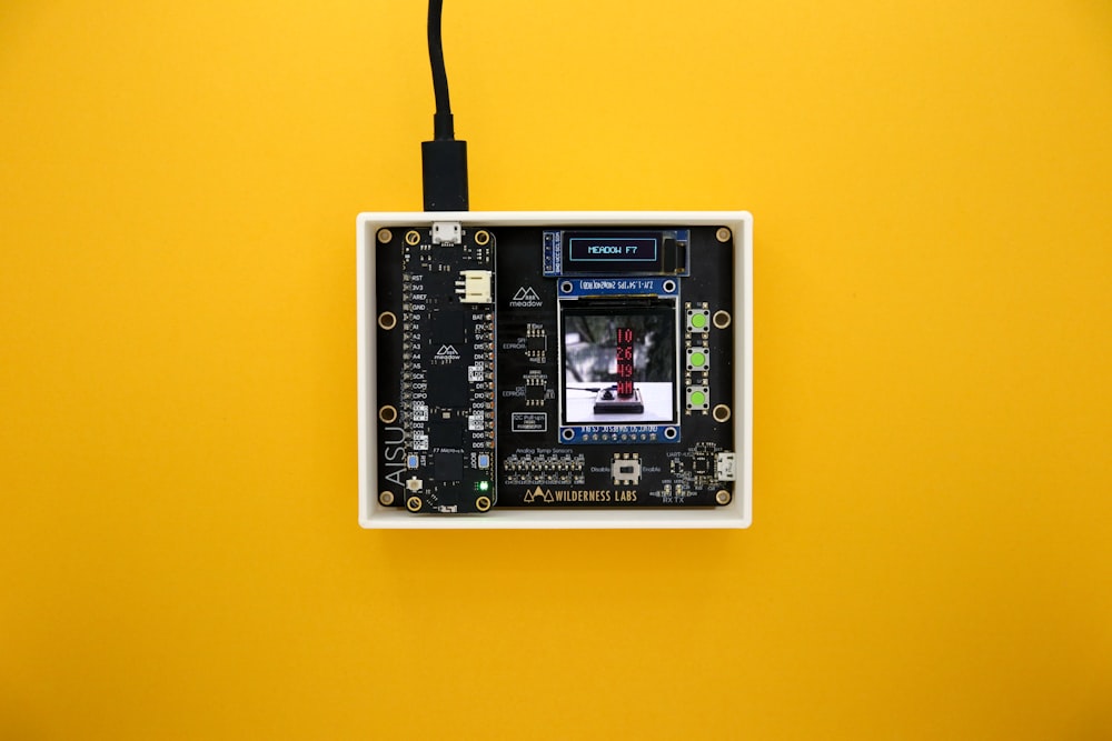 a yellow background with a black and white electronic device