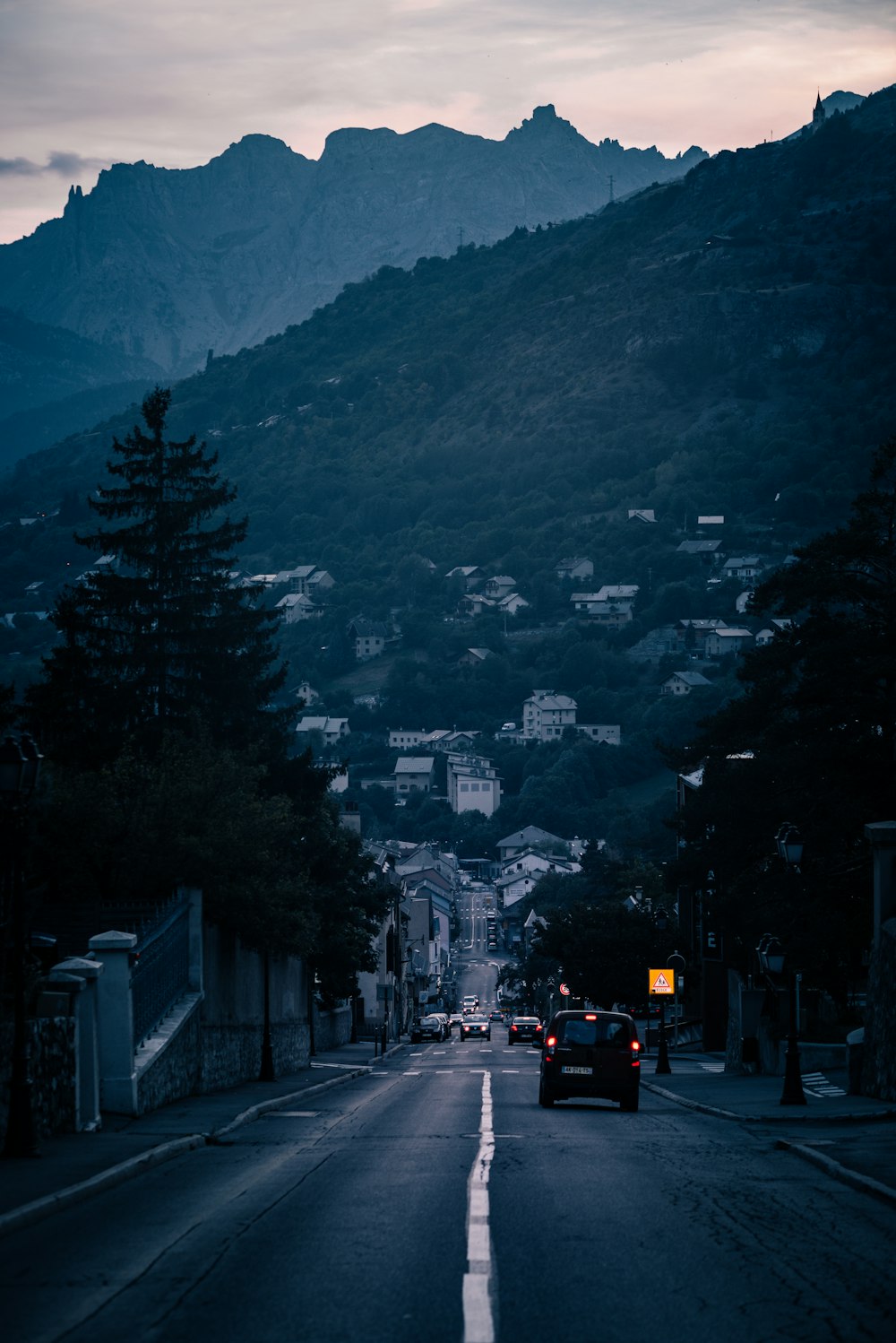 a car driving down a street with a mountain in the background