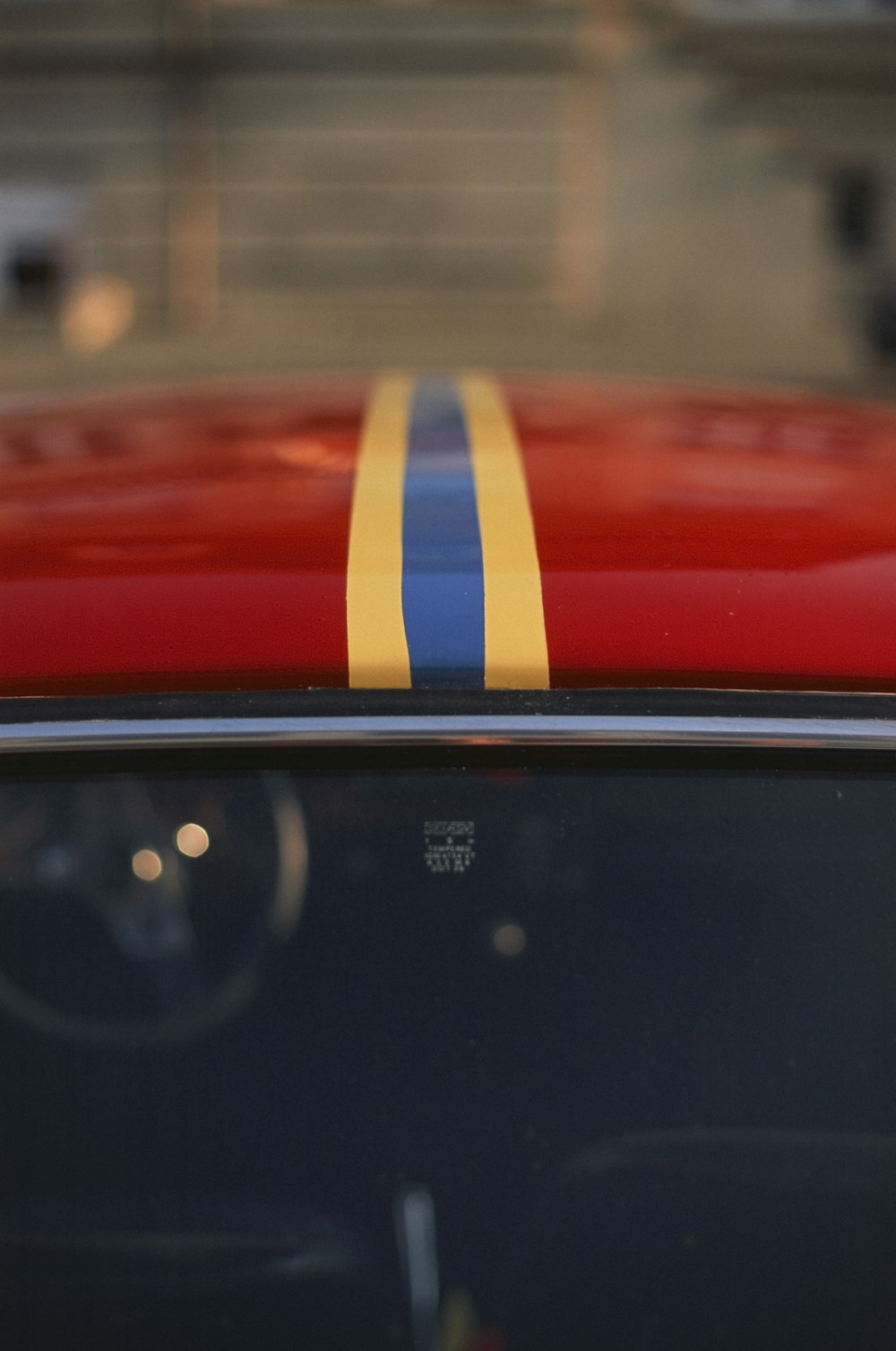 un'auto rossa con una striscia gialla e blu