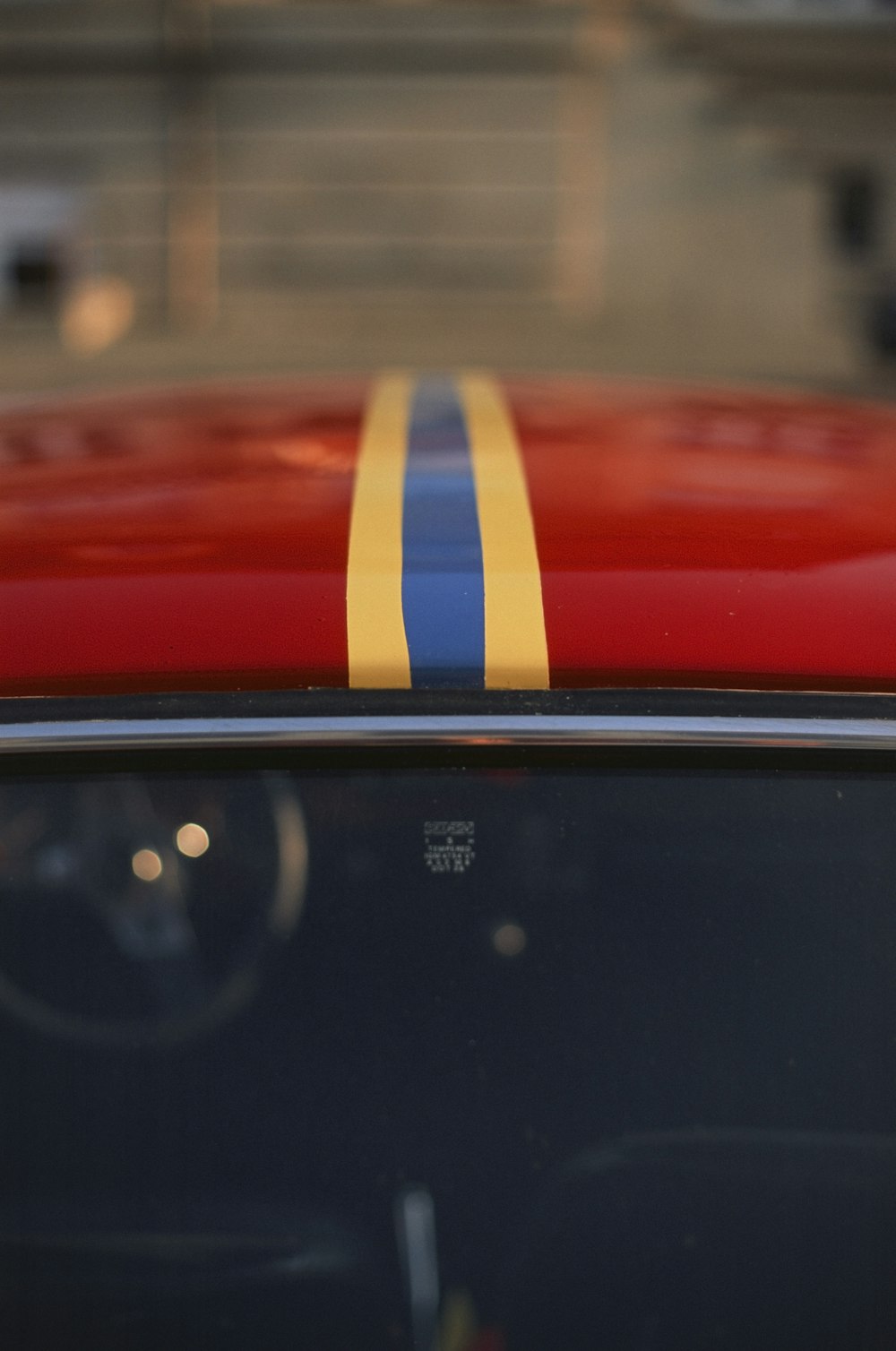 Une voiture rouge avec une bande jaune et bleue