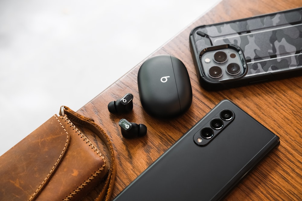 Ein Paar Kopfhörer, ein Handy und eine Brieftasche auf einem Tisch