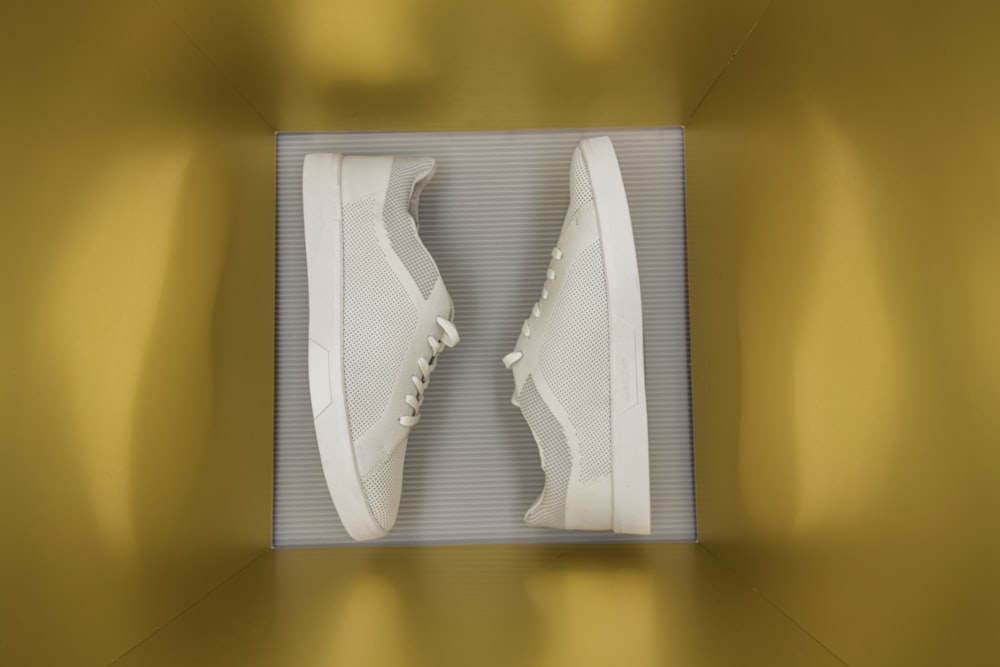 a pair of white tennis shoes in a box
