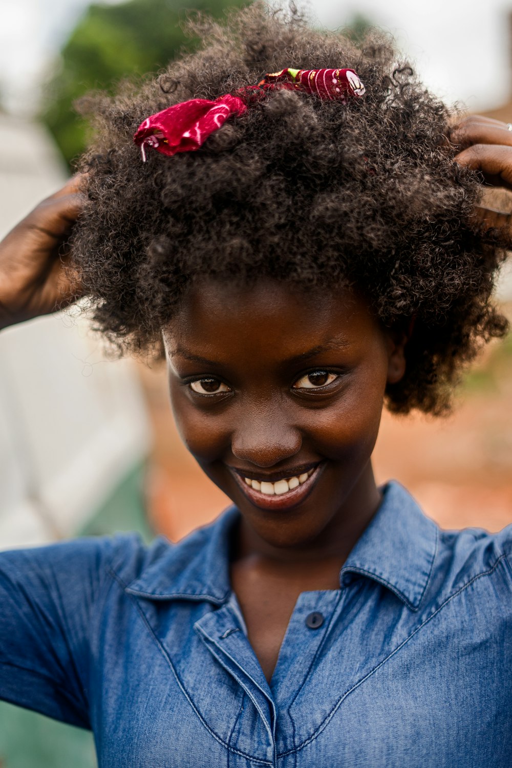 a woman with a blue shirt and a red flower in her hair