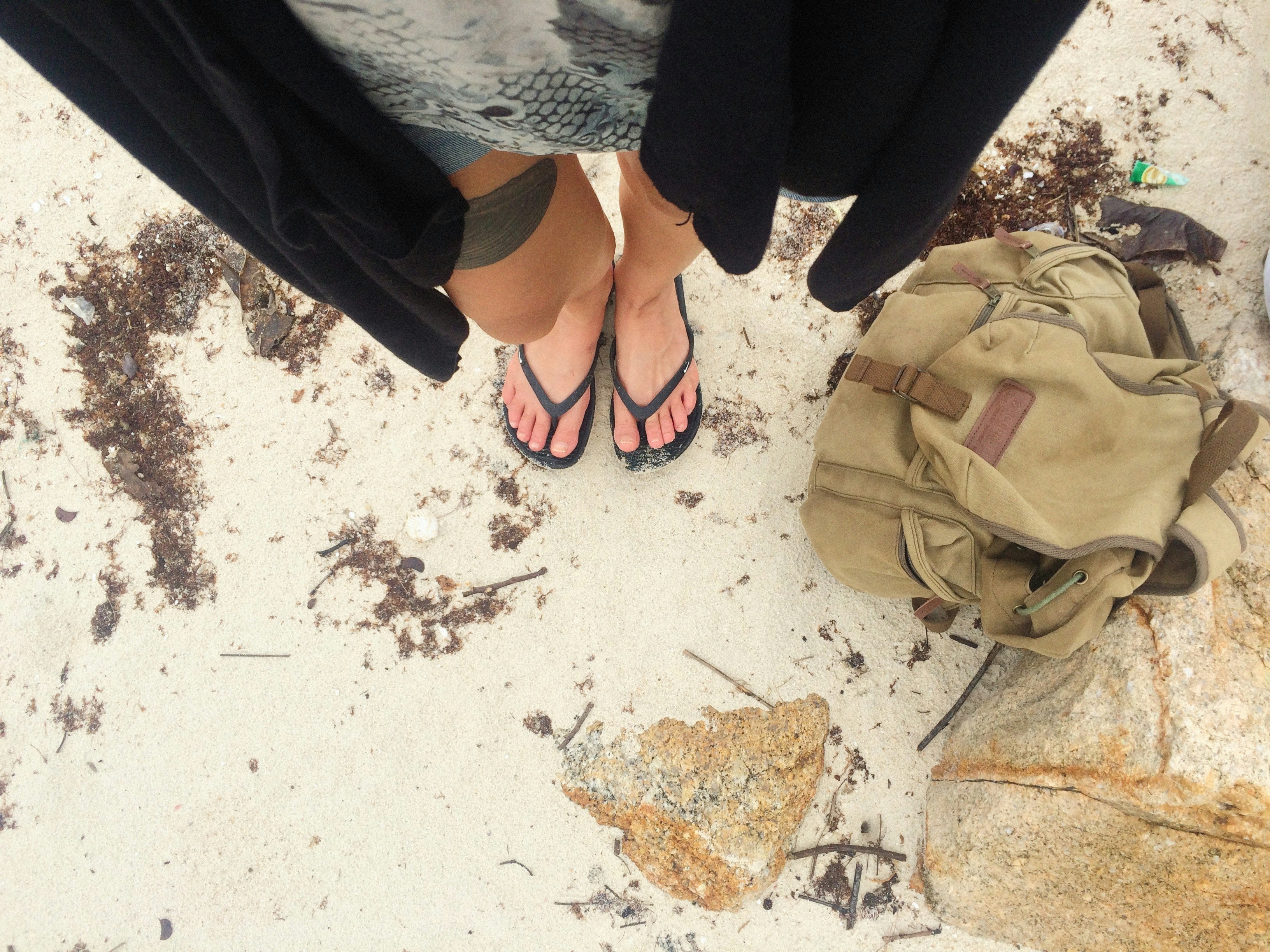 a person standing next to a backpack and a backpack