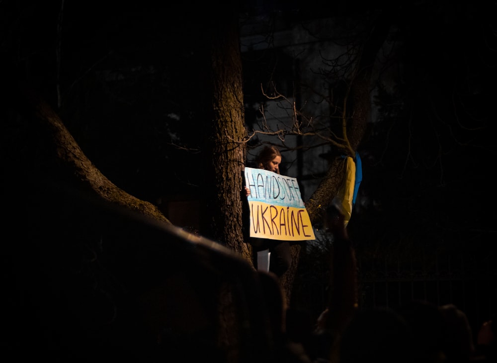 a person holding a sign in the dark