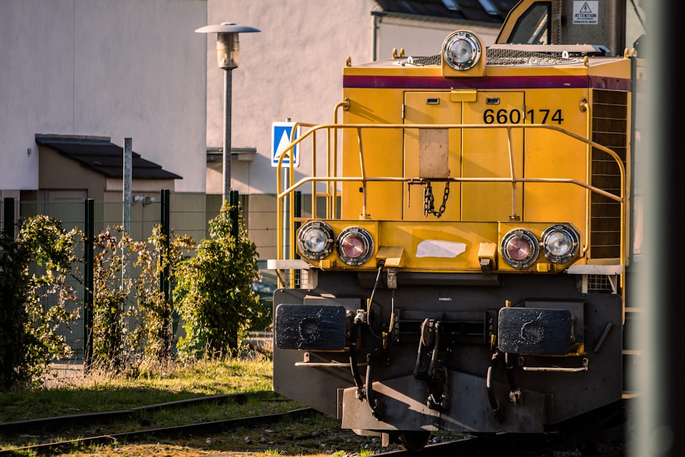 a yellow train engine sitting on the tracks