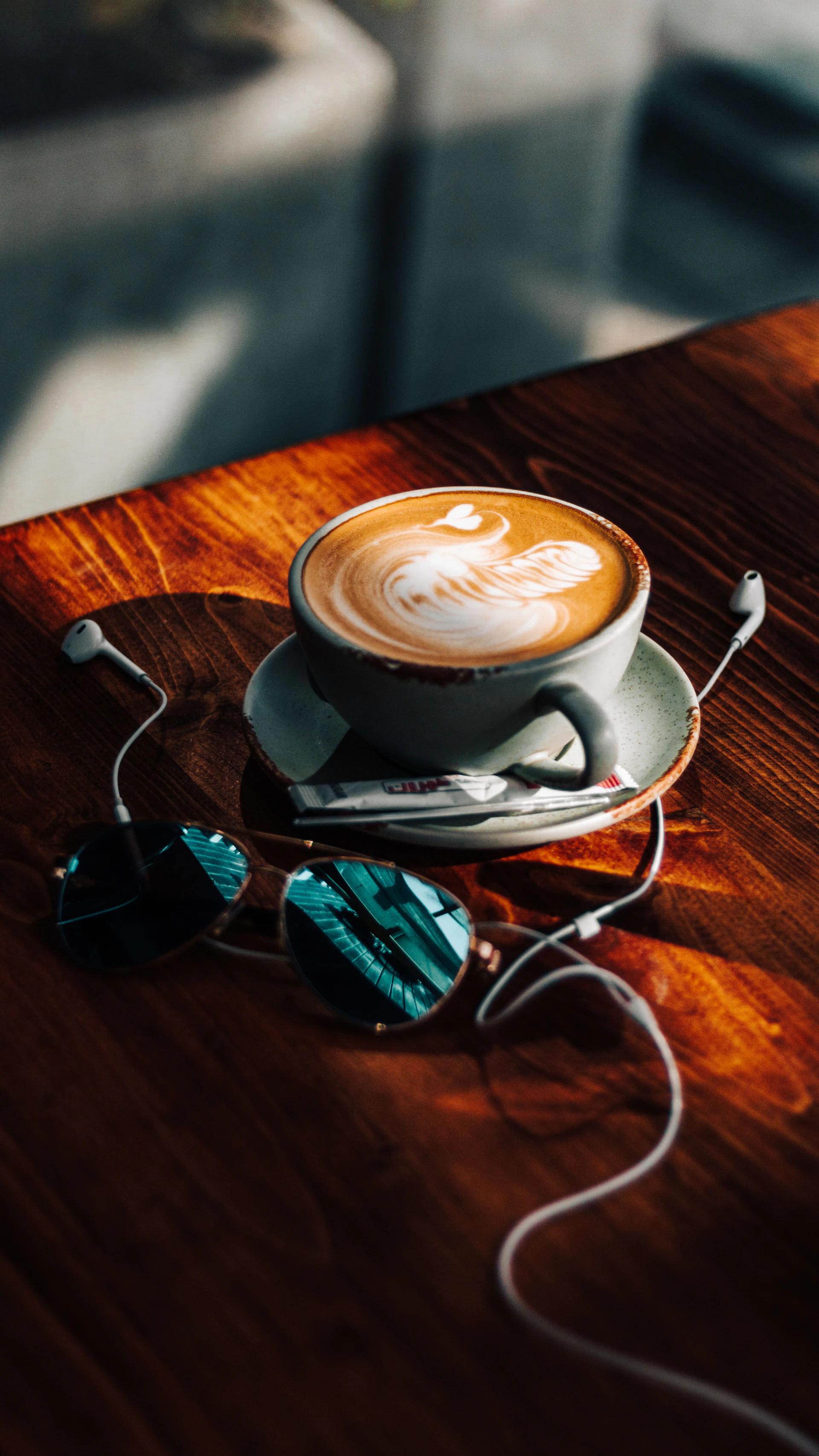 a cup of coffee sitting on top of a wooden table