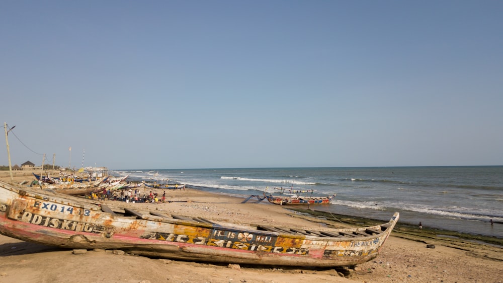 a boat sitting on top of a sandy beach