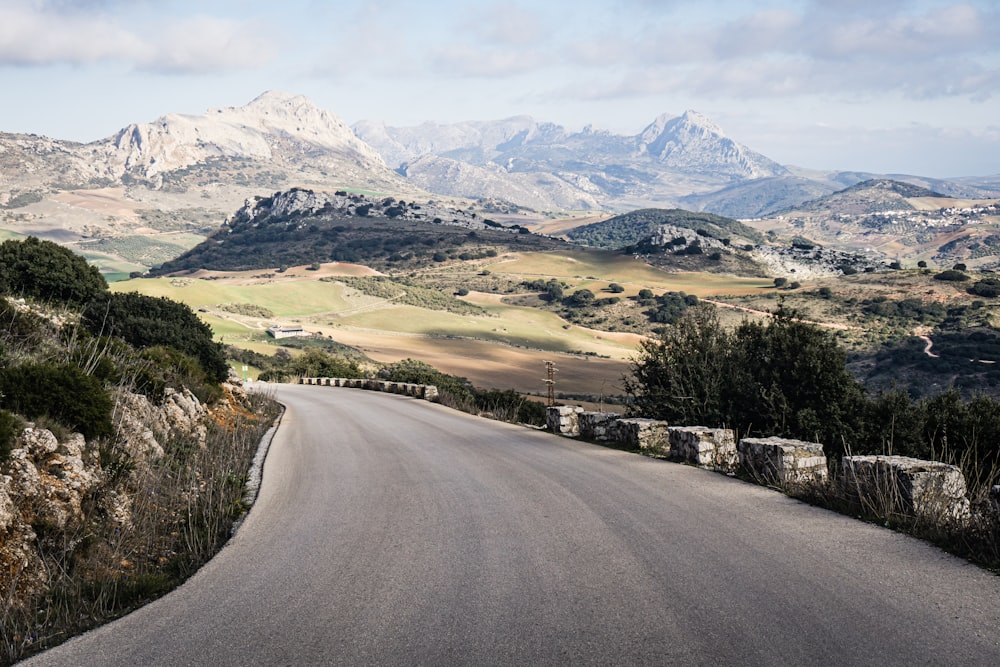 an empty road with mountains in the background