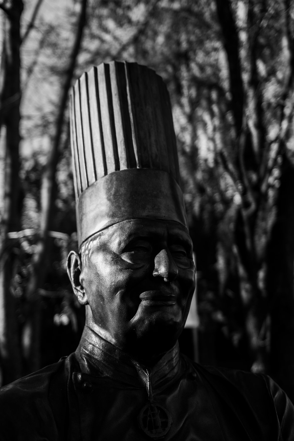 a black and white photo of a man wearing a chef's hat