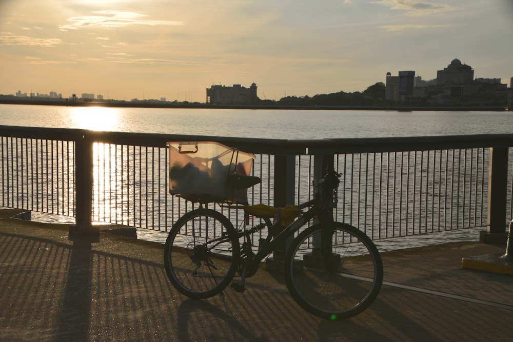 a bicycle parked next to a railing near a body of water