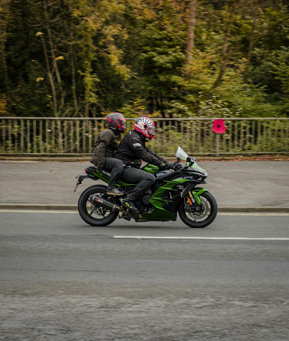 a couple of people riding on the back of a green motorcycle