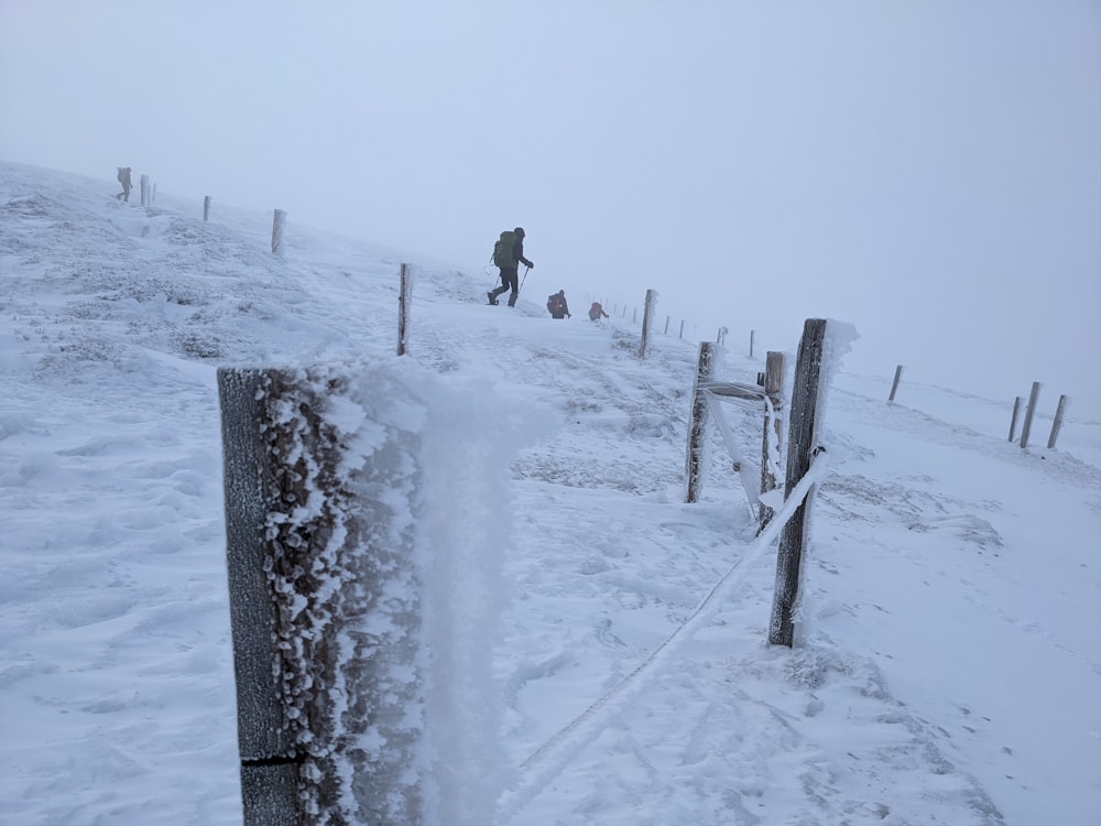 two people walking up a snowy hill in the snow